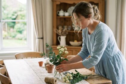 Femme arrangeant eucalyptus et fleurs blanches pour un mariage